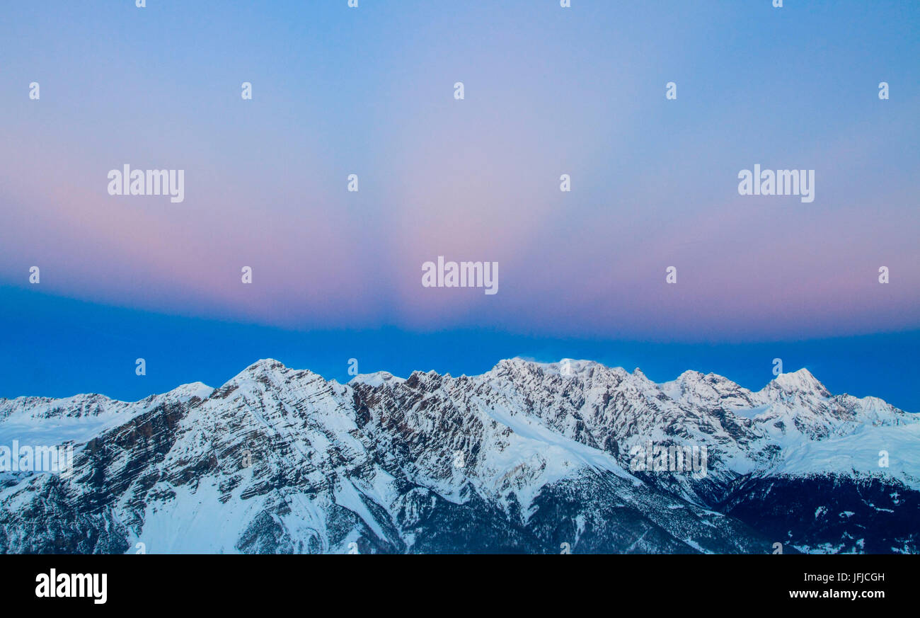 L'Europa, Italia, Lombardia, raggi di luce al tramonto sul monte Reit in Valtellina - Alpi Centrali Foto Stock