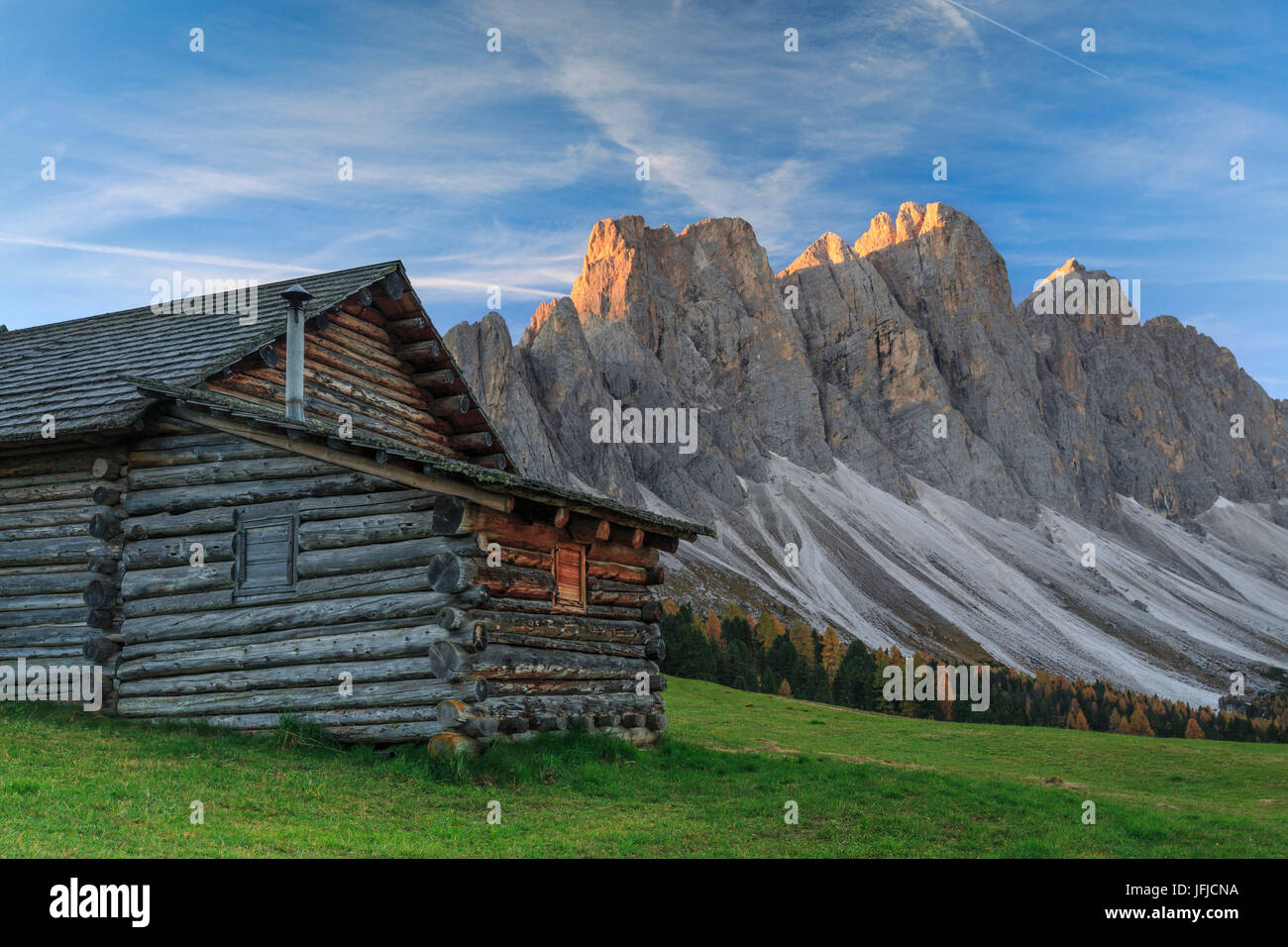 La mattina presto si illumina la Malga Gampen e le Odle in background, Val di Funes Alto Adige Dolomiti Italia Europa Foto Stock