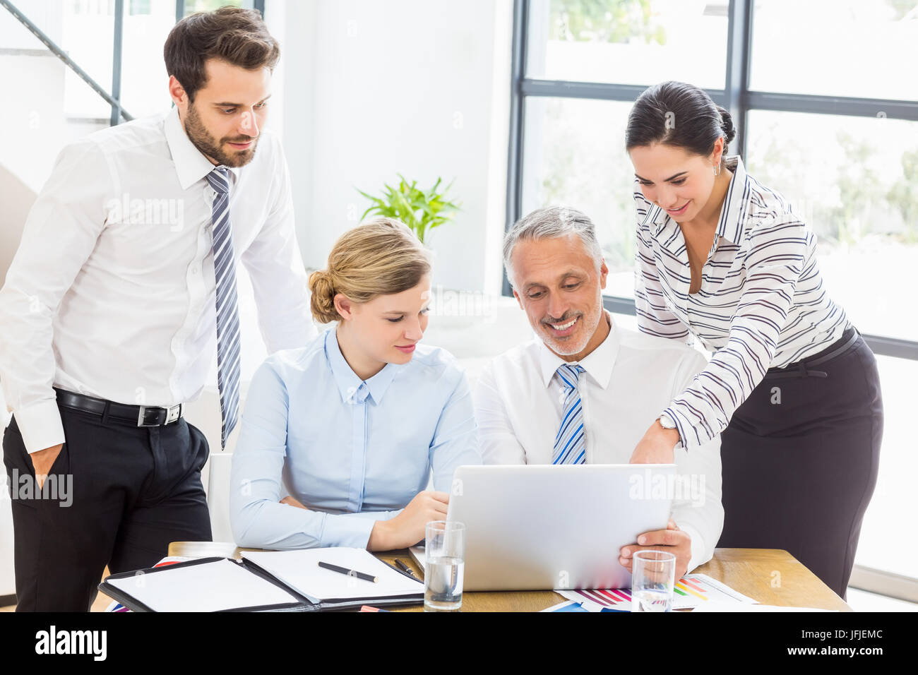 Colleghi di lavoro per discutere il lavoro di ufficio su laptop Foto Stock