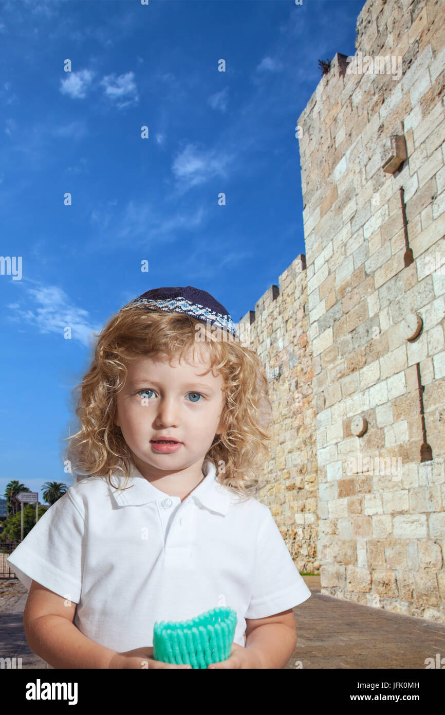 Ragazzo carino con i riccioli biondi a mura di Gerusalemme Foto Stock