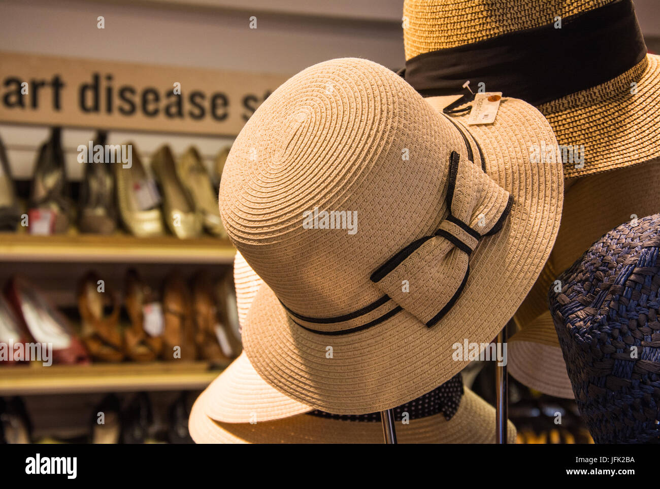 Tessuto della signora sun hat abbellito con bowknot su un cappello stand in un negozio di carità, UK. Foto Stock