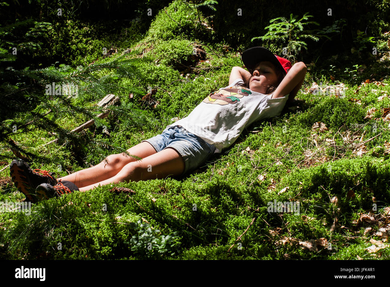 Ragazza distesa sul muschio in foresta Foto Stock