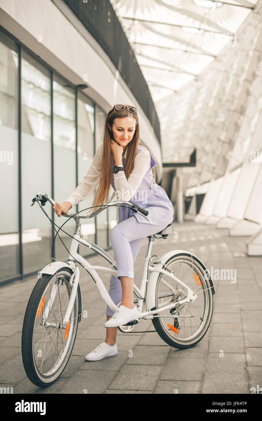A piena lunghezza shot di una bellissima giovane imprenditrice con la sua bici Foto Stock