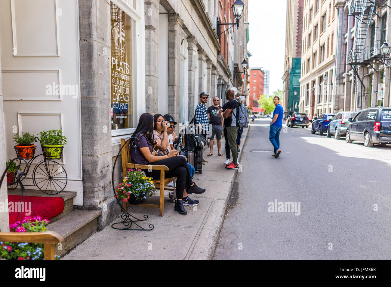 Montreal, Canada - 28 Maggio 2017: la zona della città vecchia con la gente seduta sulle panchine su strada durante la giornata di sole al di fuori di ristoranti nella regione di Québec city Foto Stock