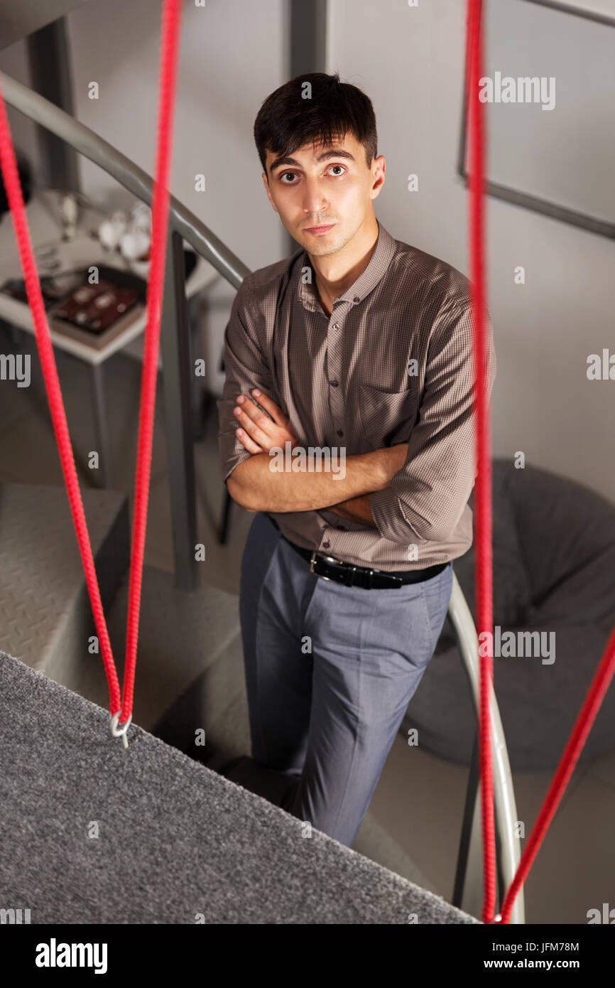 Giovane uomo bello in piedi sui gradini in office Foto Stock