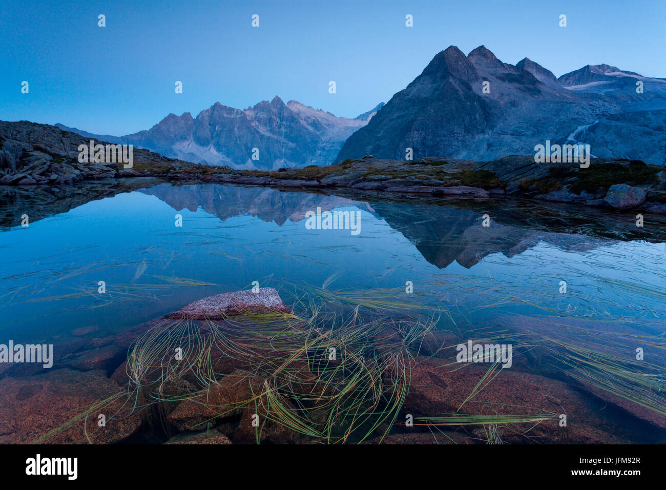 La Val Genova, Carisolo, Parco Naturale Adamello Brenta, Trentino Alto Adige, Italia, tre Lobbie sono riflesse in uno dei numerosi laghi che punteggiano la pianura dove il rifugio è situato Mandron Foto Stock