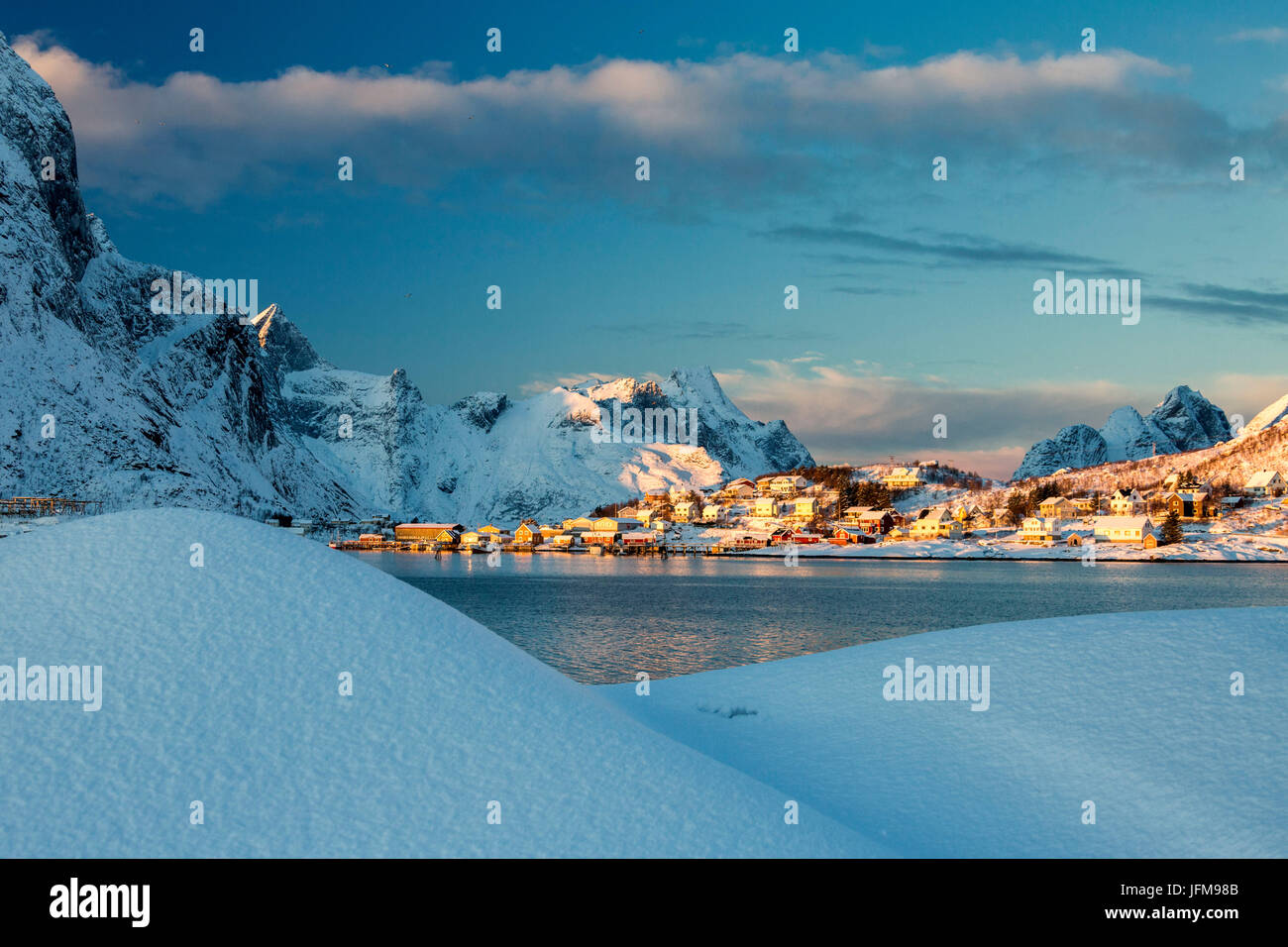 Il colore blu del crepuscolo sul villaggio di pescatori e le cime innevate Kvalvika Andøya Reine Nordland Isole Lofoten in Norvegia Europa Foto Stock