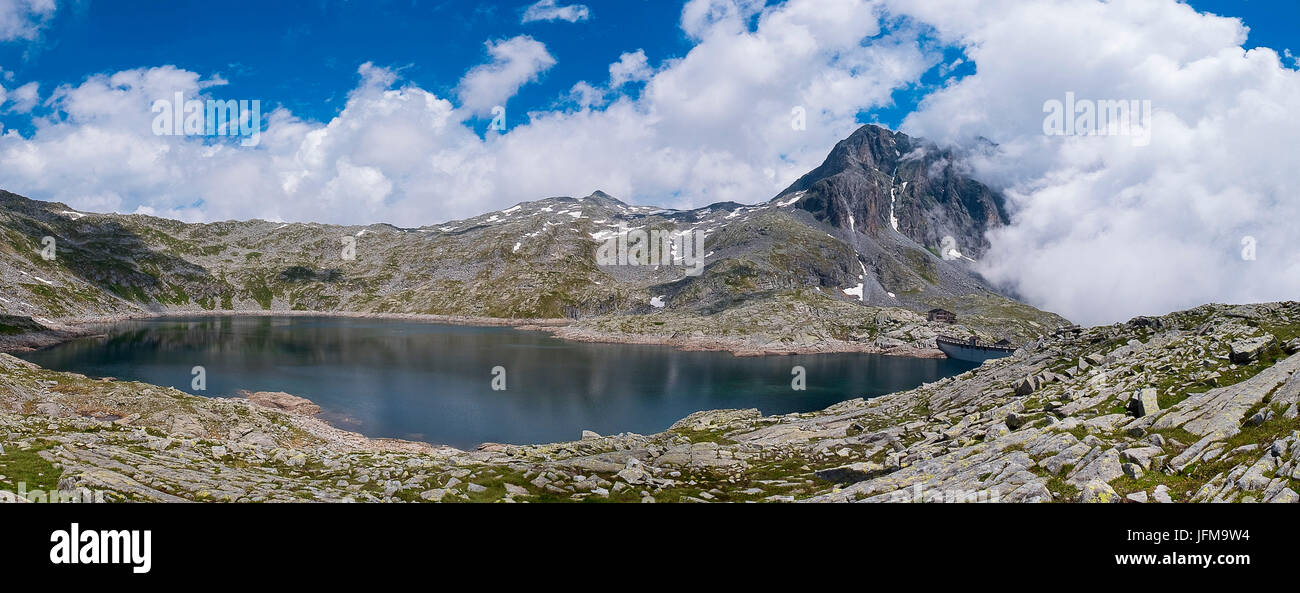 Gaver, Parco Adamello, Lombardia, Italia immagine panoramica del Lago della Vacca, è possibile vedere il lago, il Monte Blumone, il rifugio Tita Secchi con la diga vicino Foto Stock