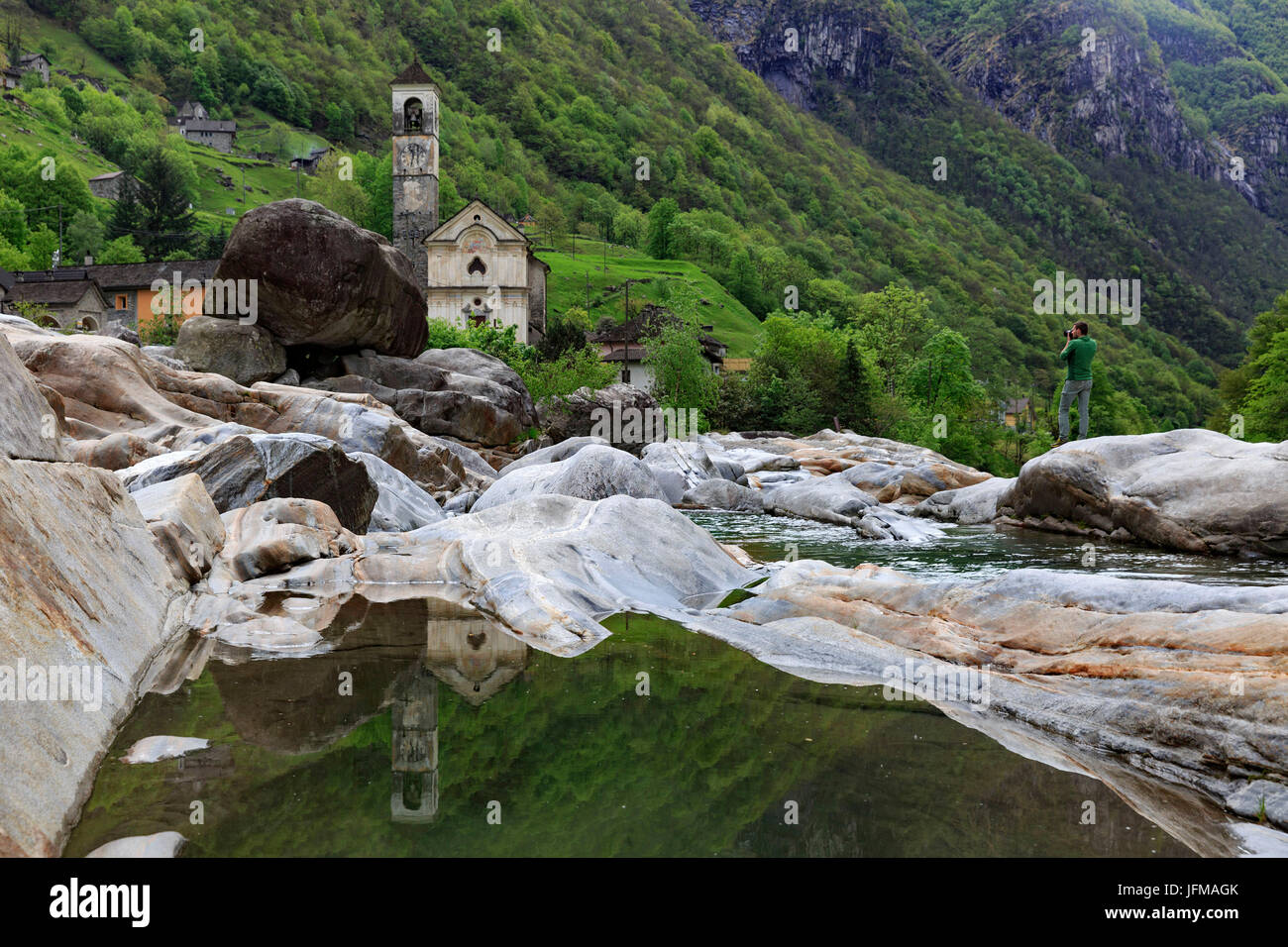 Fotografo di scattare una foto della chiesa di Lavertezzo, dalle bellissime rocce della Verzasca stream, Lavertezzo, Ticino, Svizzera Foto Stock