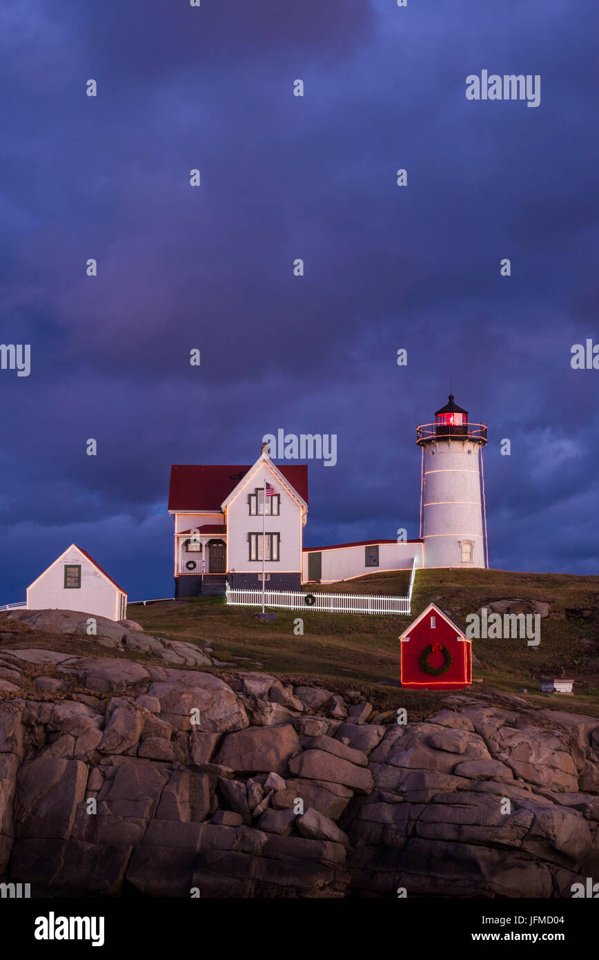 Stati Uniti d'America, Maine, York Beach, Nubble Luce faro con decorazioni di Natale, crepuscolo Foto Stock