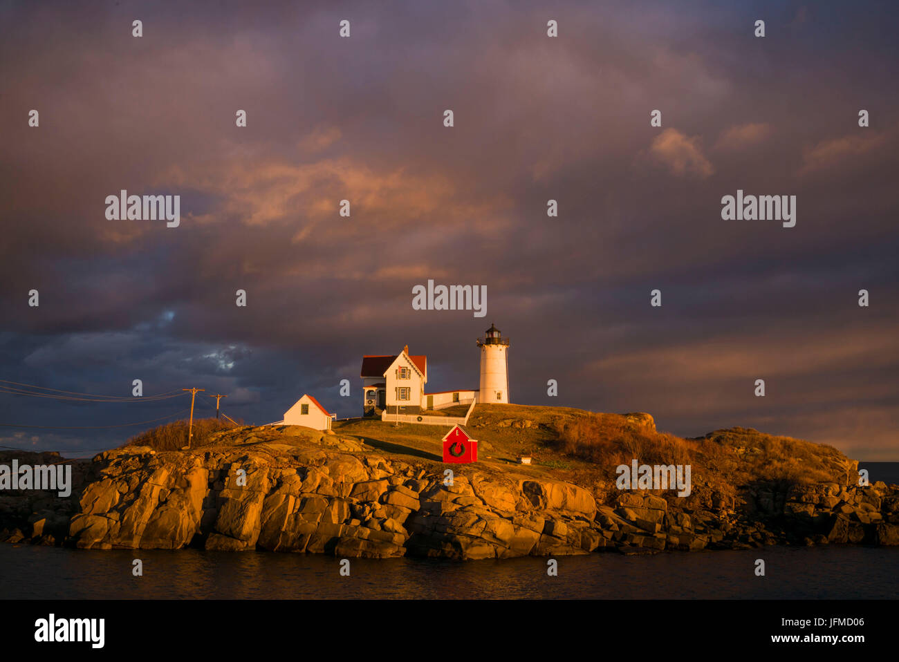Stati Uniti d'America, Maine, York Beach, Nubble Luce faro con decorazioni di Natale, sunset Foto Stock
