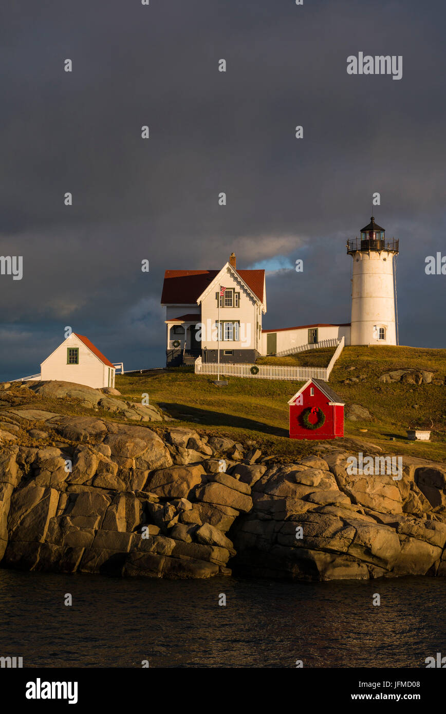 Stati Uniti d'America, Maine, York Beach, Nubble Luce faro con decorazioni di Natale, sunset Foto Stock