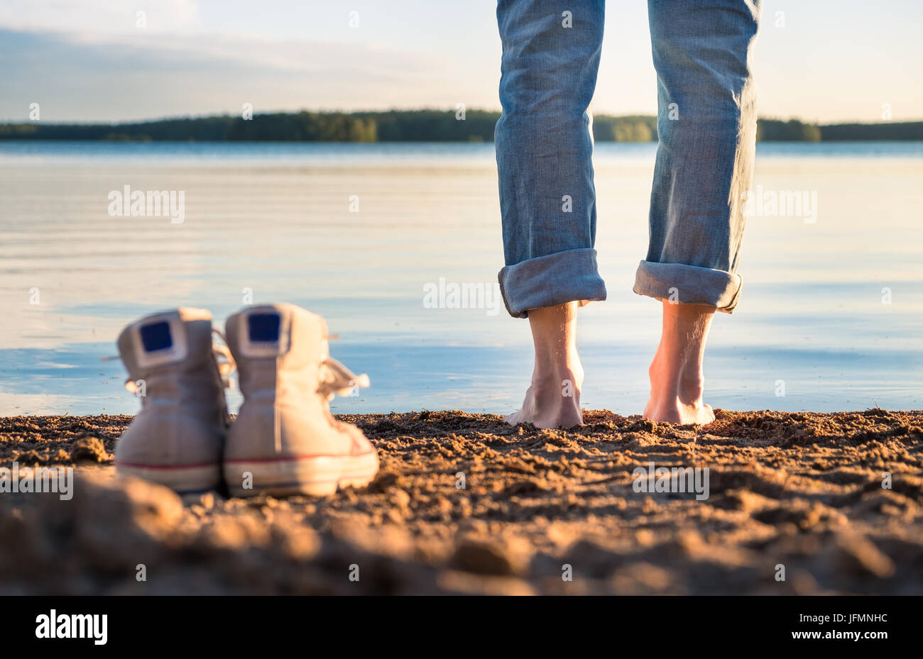 Uomo in piedi in spiaggia a bella serata estiva in Finlandia. Foto Stock