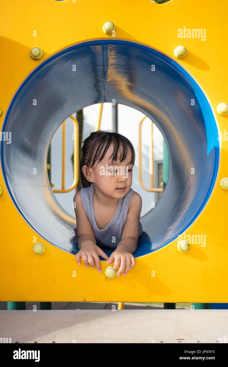 Cinese asiatici bambina giocando in tunnel al parco giochi all'aperto Foto Stock