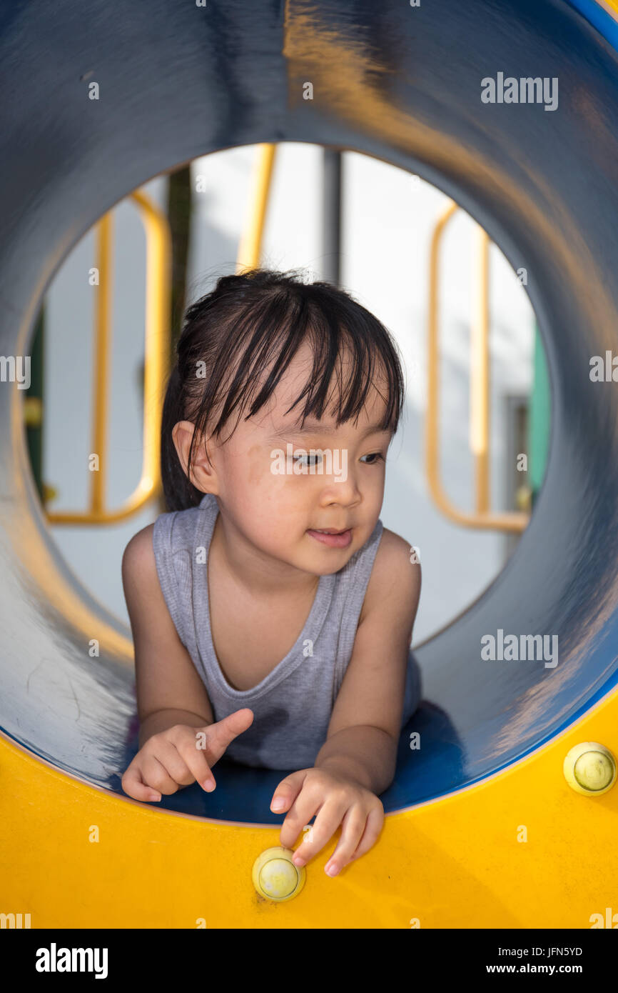 Cinese asiatici bambina giocando in tunnel al parco giochi all'aperto Foto Stock