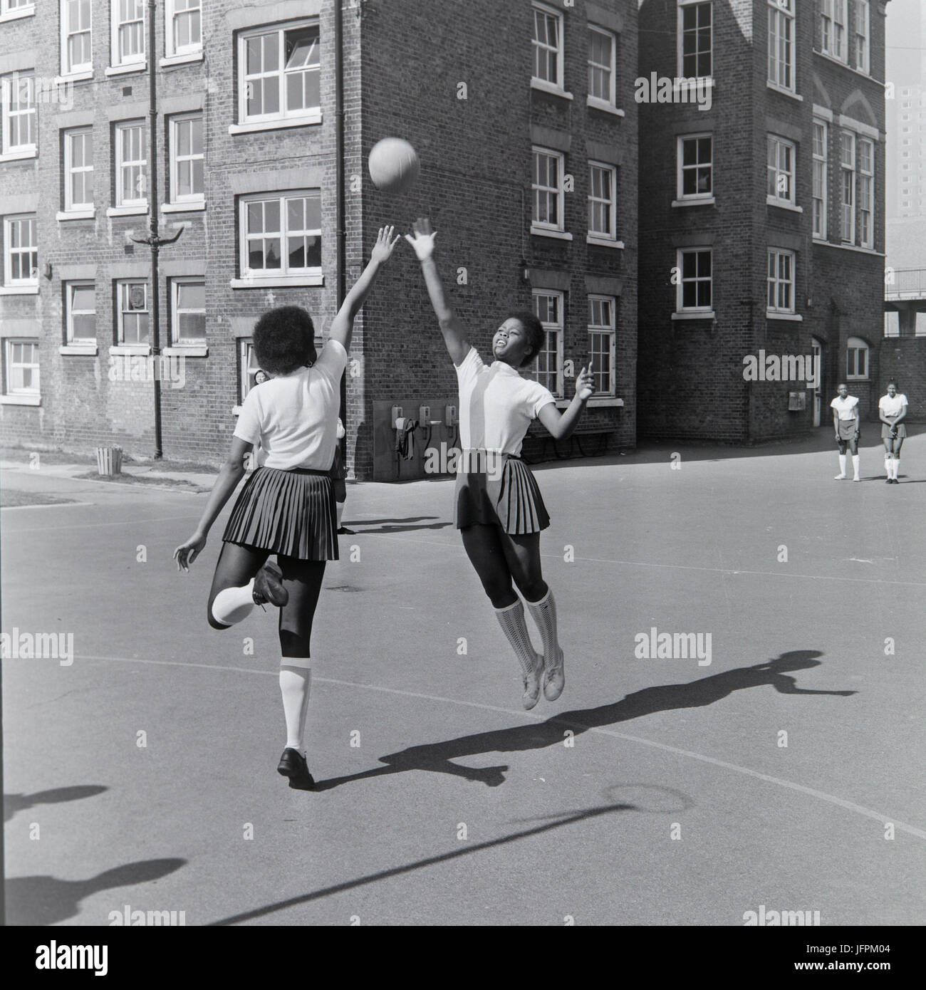 Due nero, afro-caraibica ragazze giocando netball a Londra, Inghilterra, durante gli anni settanta. Foto Stock