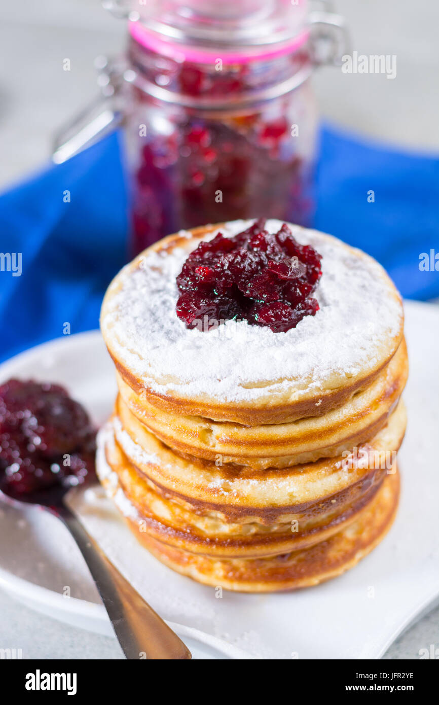 In casa frittelle americana servita con rosso marmellata di mirtilli sul tovagliolo blu, Americal bandiera colori, colazione in stile americano Foto Stock