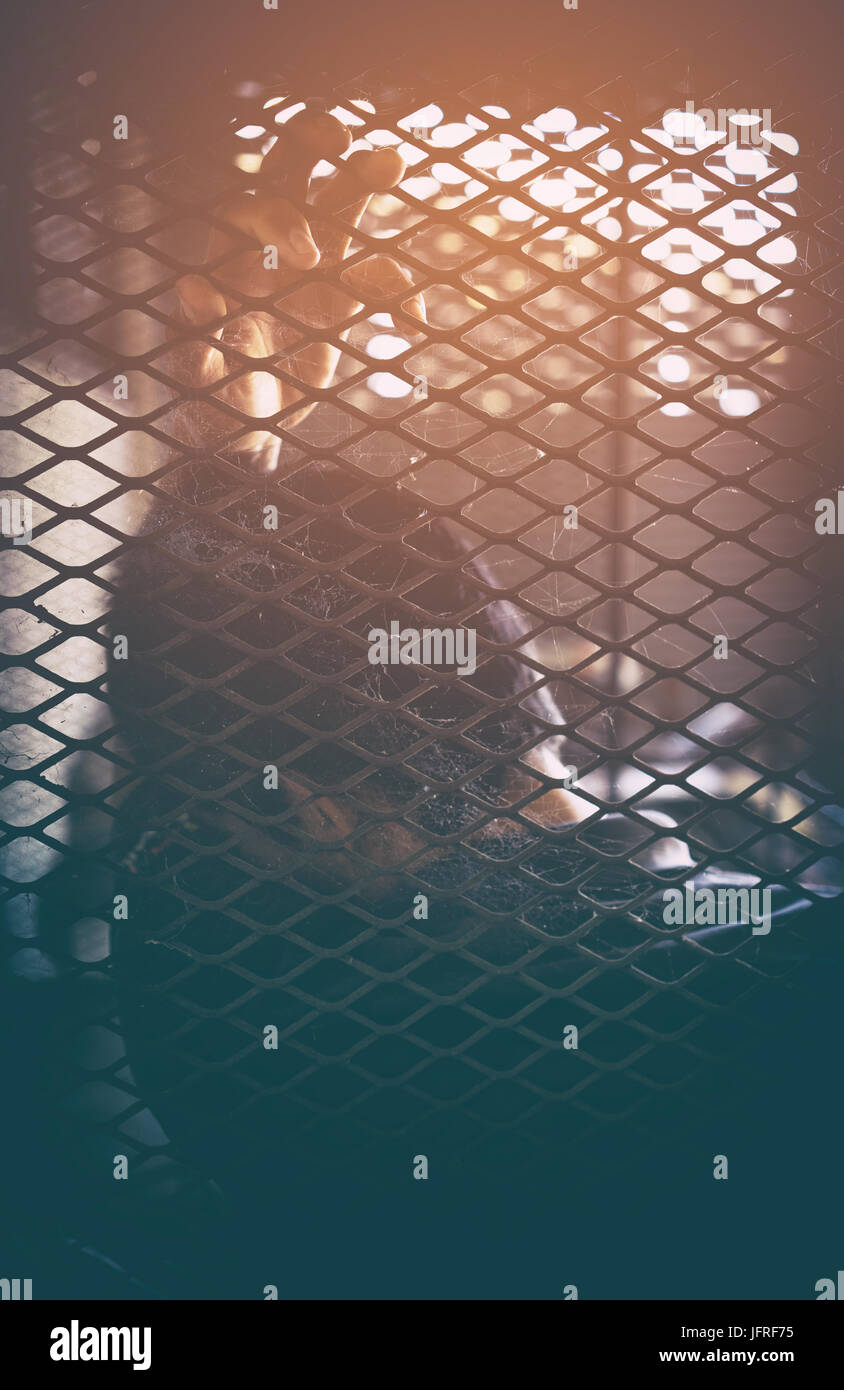 Il traffico di esseri umani, l'uomo in gabbia con luce arancione Foto Stock