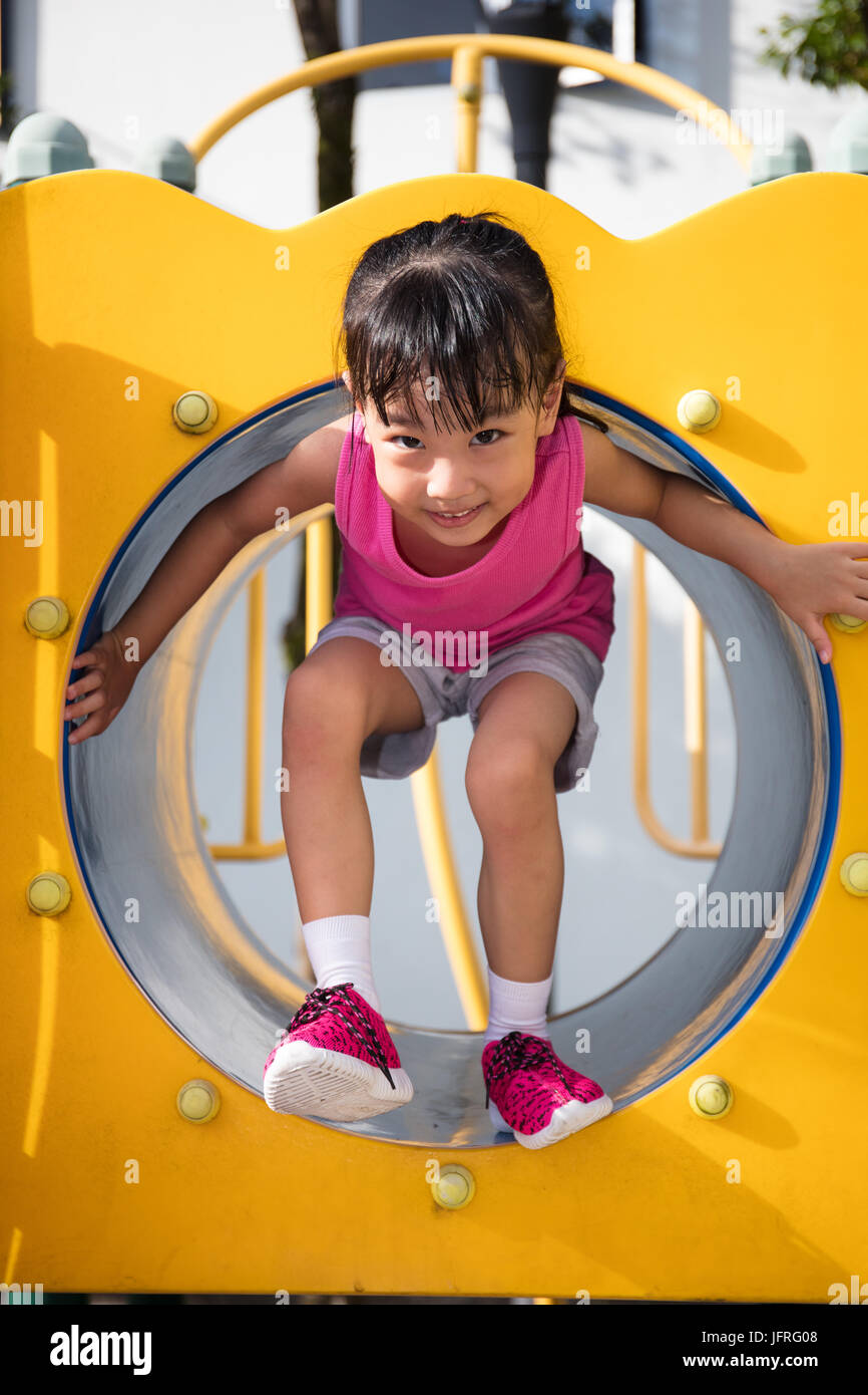 Cinese asiatici bambina giocando in tunnel al parco giochi all'aperto Foto Stock