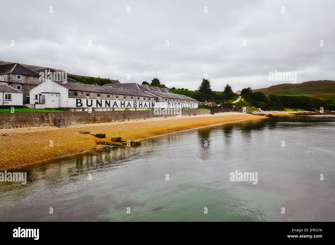 ISLAY, Regno Unito - 26 August 2013: Bunnahabhain distillery fabbrica dal mare, Islay, Regno Unito Foto Stock