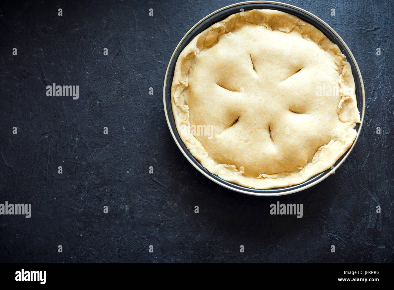 La cottura di una torta. Crudi torta di pasta frolla (pasta, riempimento) in una teglia, la preparazione per la cottura. Torta di greggio, pronto per cuocere al forno, il processo di cottura. Foto Stock