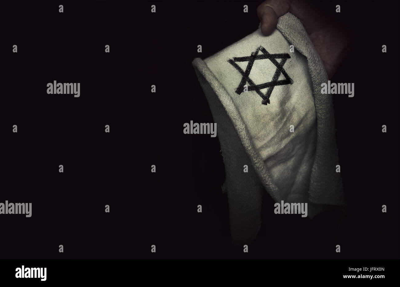 Primo piano del badge ebraica stella di Davide in mano. Il concetto della memoria del genocidio degli ebrei da parte dei nazisti durante la seconda guerra mondiale. Foto Stock
