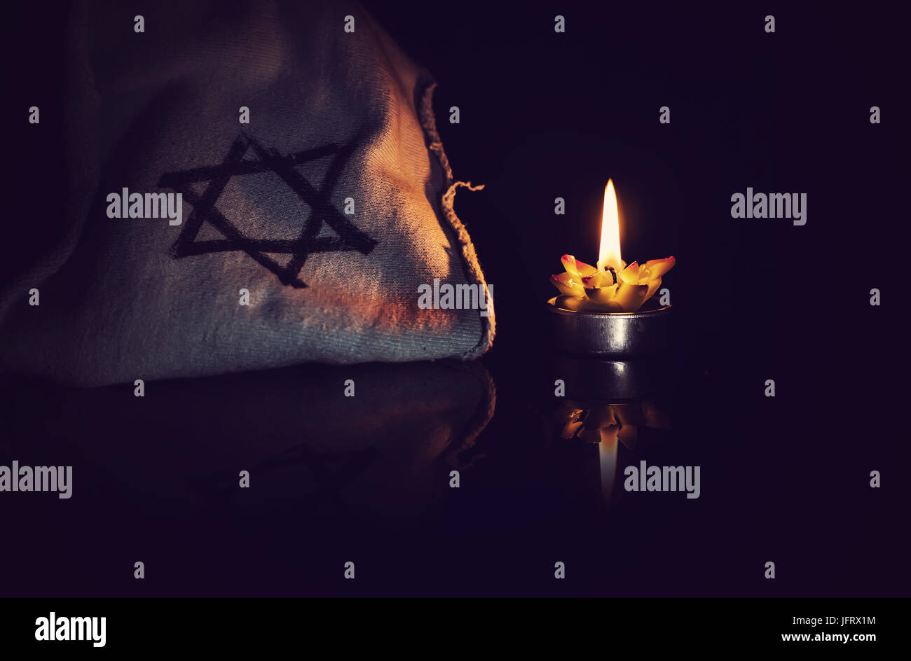 Candela che brucia e la stella di Davide contro uno sfondo nero, non dimenticheremo mai la Shoah ebraica e di eroismo Giorno del Ricordo Foto Stock