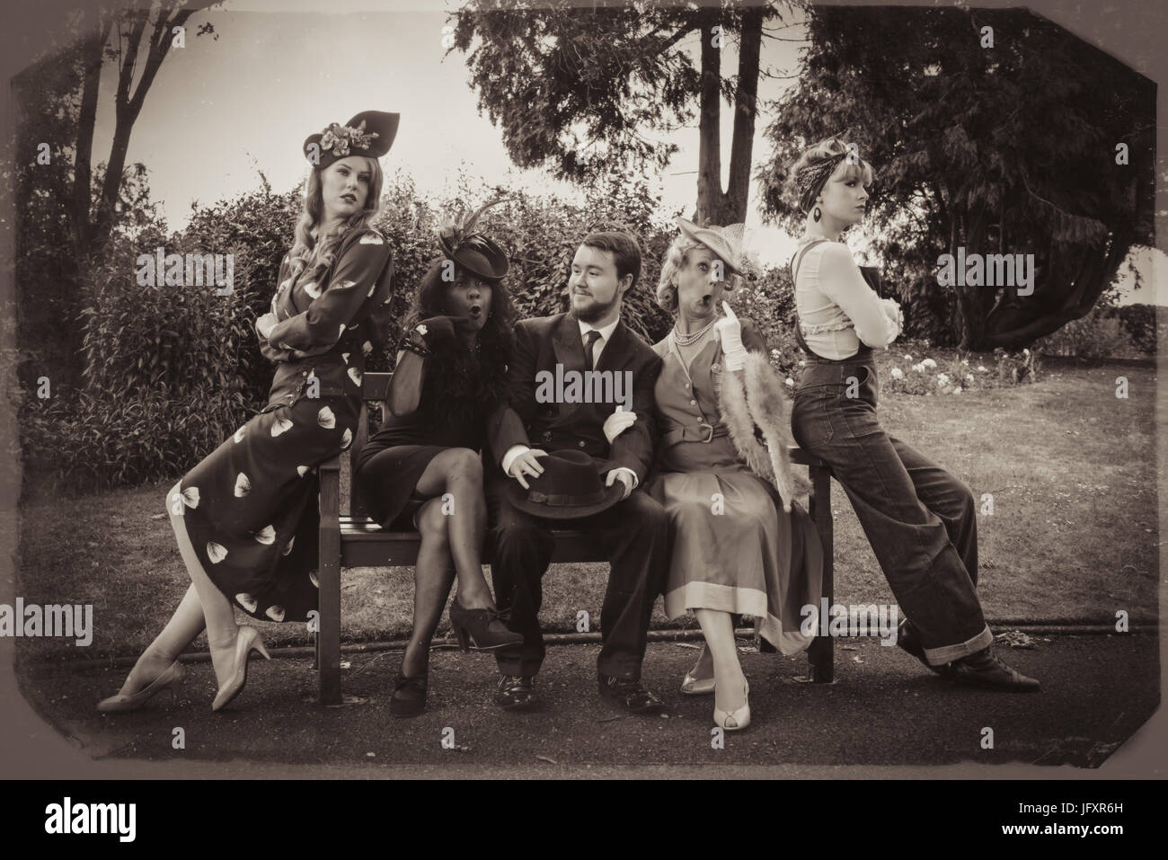 La gente seduta su una panchina nel parco in Bridgnorth park vestito in costume d'epoca come parte della Severn Valley Railway Torna alla 1940's evento Giugno 2017 Foto Stock
