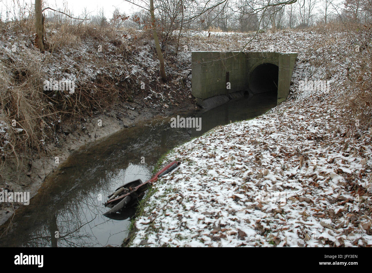 Paesaggio di piccole streamlet che entra in un tubo, un rip rullo motore è stata scagliata nel flusso. Foto Stock