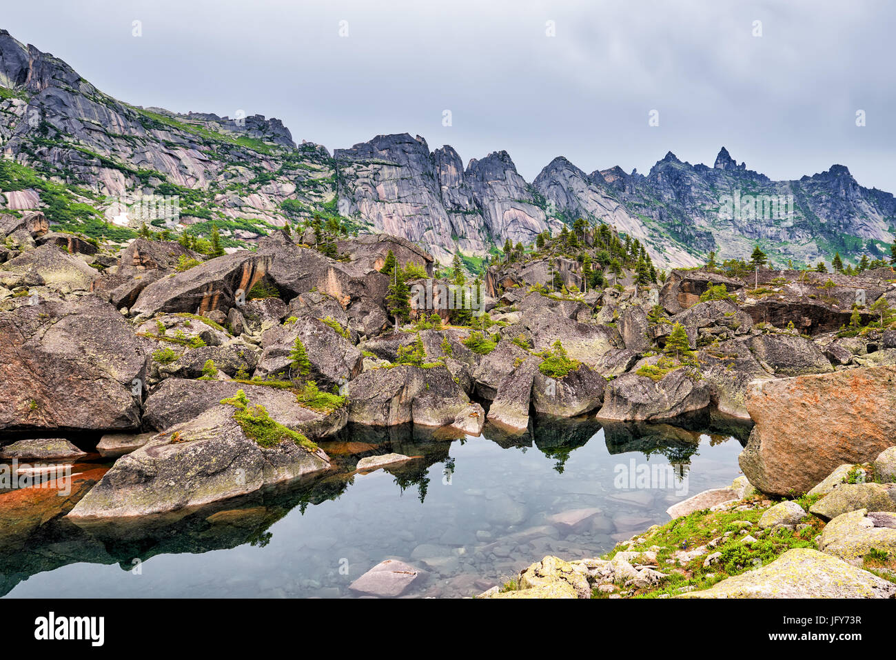 Piccolo lago di montagna nella morena glaciale da grandi massi. Ergaki Ridge. Western Sayan. Asia centrale Foto Stock