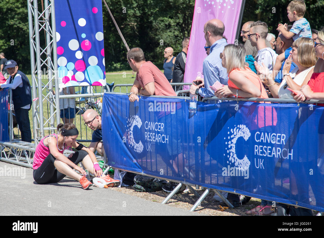 Southampton, Regno Unito. 02Luglio, 2017. Giovane atleta, che soffrono di esaurimento di calore, è di aiuto da parte degli astanti al traguardo della corsa per la vita. Questa gara annuale è gestito da donne per raccogliere fondi per la ricerca sul cancro. Credito: Jane Rix/Alamy Live News Foto Stock