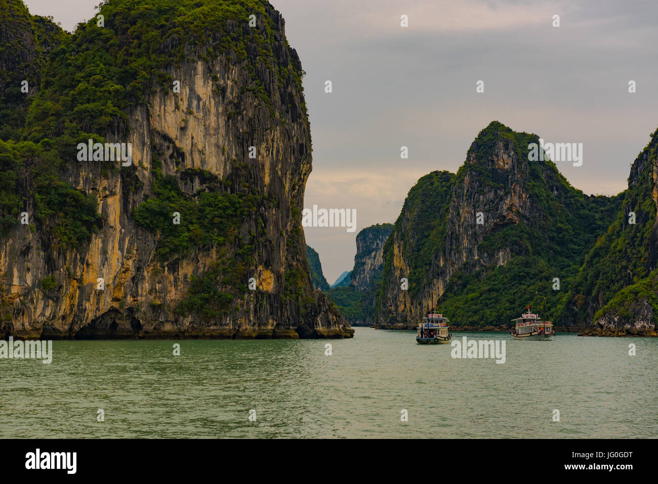 La Baia di Ha Long, Vietnam -- Marzo 24, 2016. Tour di due barche a vela sulla Baia di Ha Long in Vietnam attraverso uno stretto passaggio attraverso una formazione rocciosa. Editoriale Foto Stock