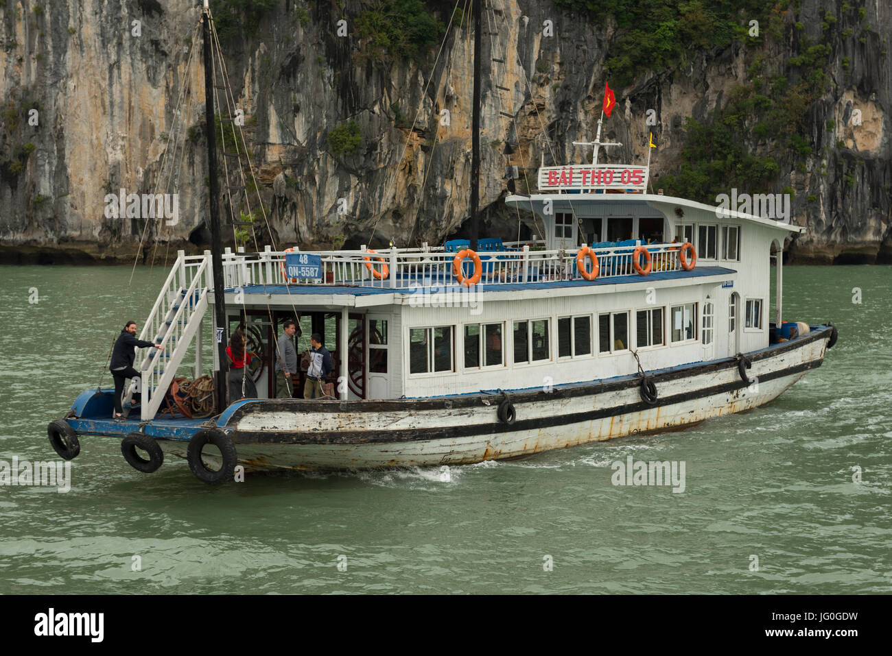 La Baia di Ha Long, Vietnam -- Marzo 24, 2016. Una barca a vela sulla Baia di Ha Long in Vietnam presso la scogliera di una formazione di roccia. Solo uso editoriale. Foto Stock