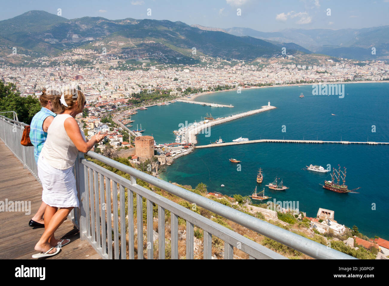 Due donne ai turisti di ammirare la vista sul porto di Alanya, Turchia Foto Stock