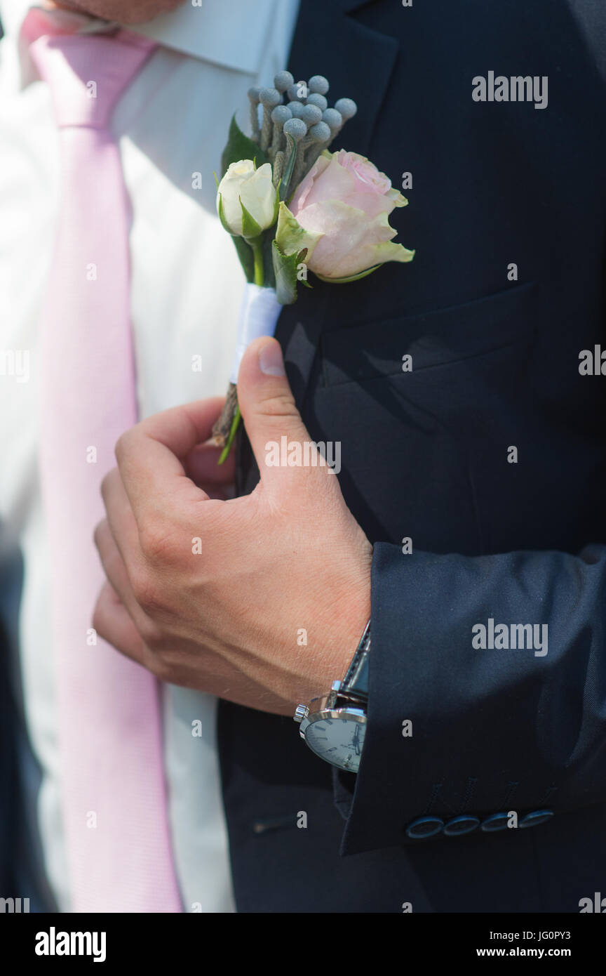 Boutonniere per lo sposo con una rosa rosa su un giorno di nozze Foto Stock