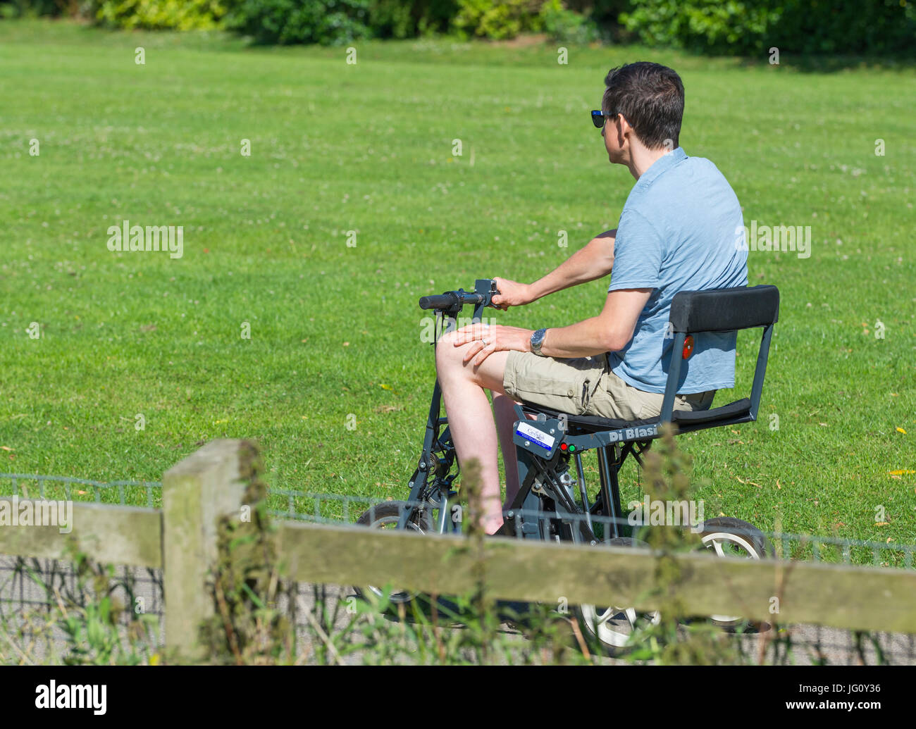 Giovane uomo disabili su una mobilità elettrica scooter. Foto Stock