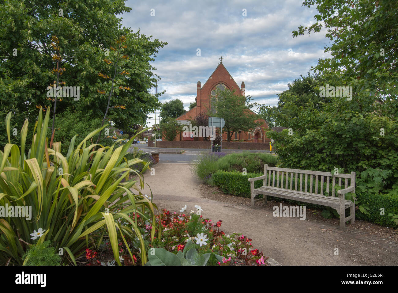 San Marco Chiesa a Farnborough, Hampshire, Regno Unito, in estate con fiori in primo piano Foto Stock