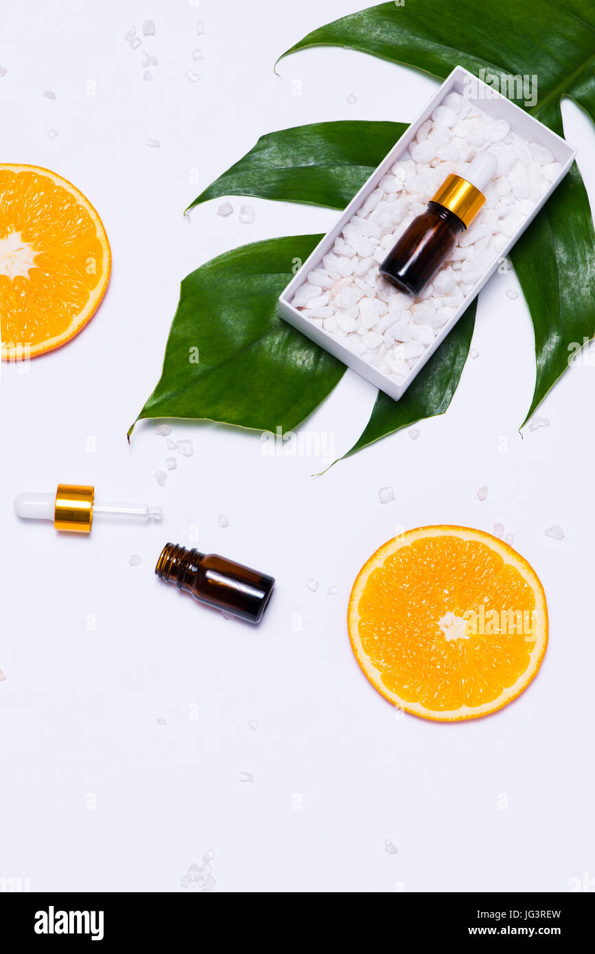 Il Branding mock-up. Olio essenziale naturale, bottiglia di cosmetici contenitori con fettine di arancia. Foto Stock