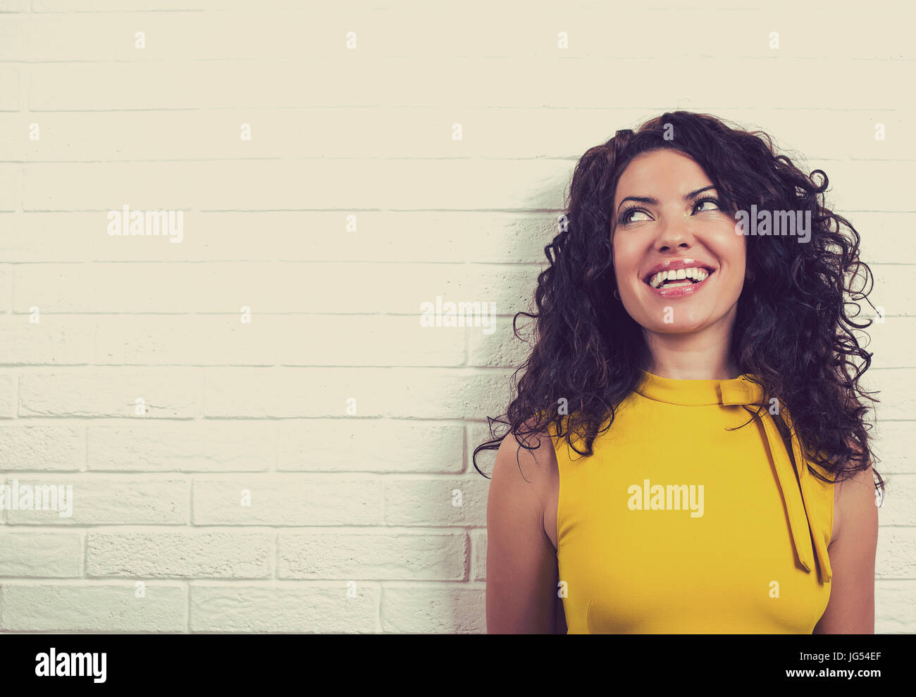 Ridendo donna felice, isolato su un muro di mattoni dello sfondo. Positivo emozione umana sentimenti Foto Stock