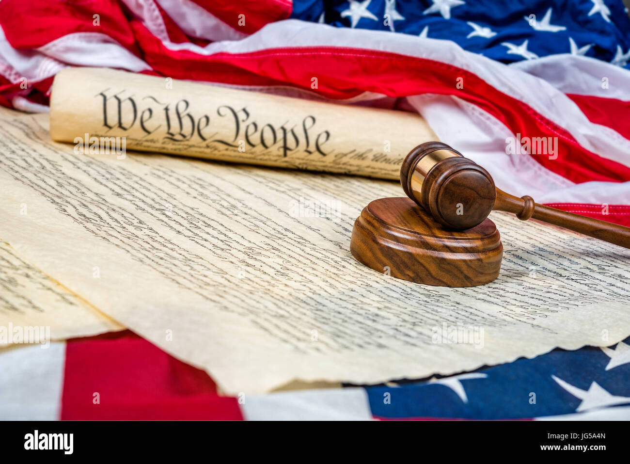 La costituzione degli Stati Uniti arrotolata su una bandiera americana con un martello in primo piano. Camera per copia lungo la parte sinistra dell'immagine. Foto Stock
