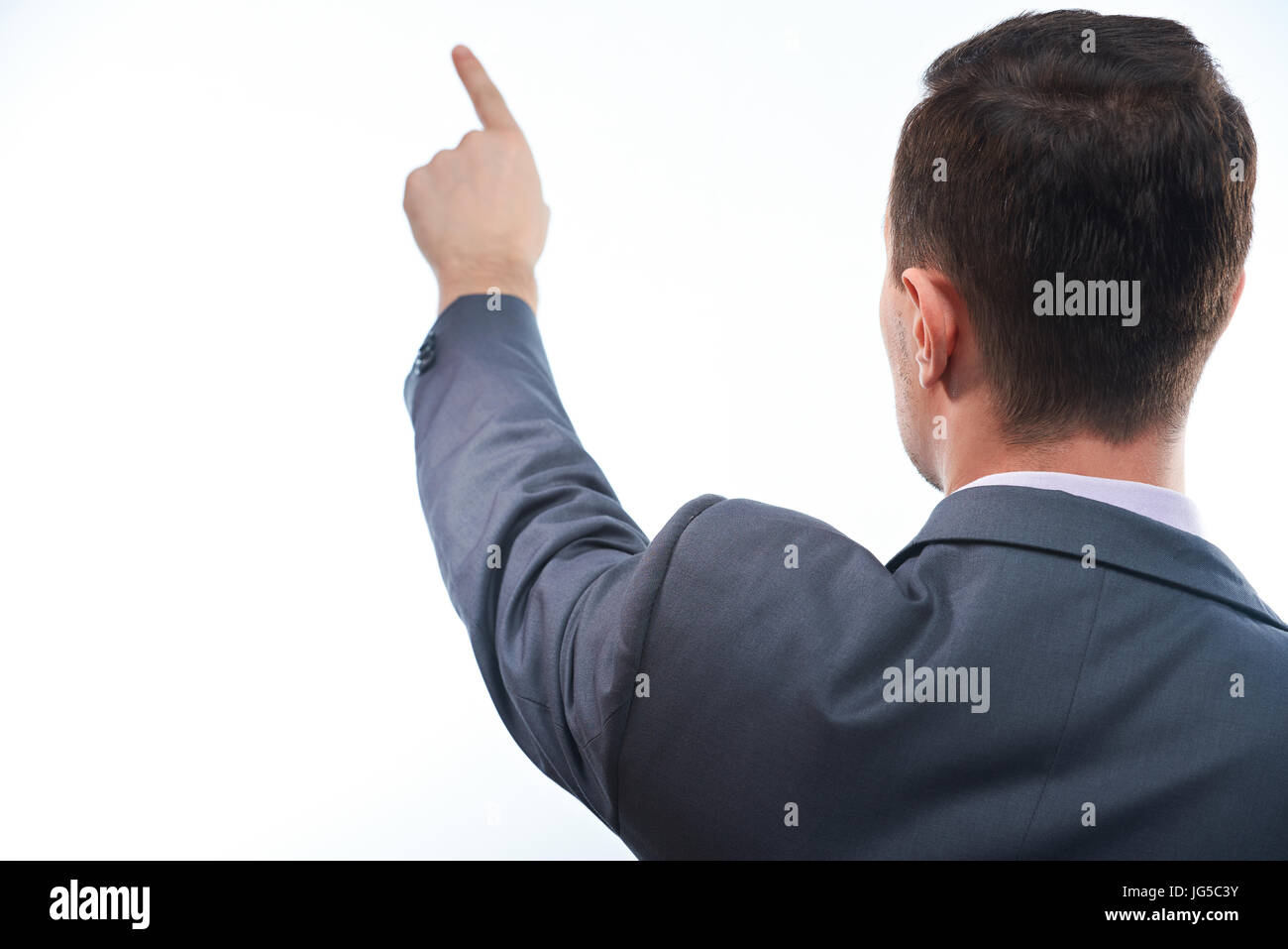 Uomo di Business point con il dito vista posteriore isolato su sfondo bianco Foto Stock