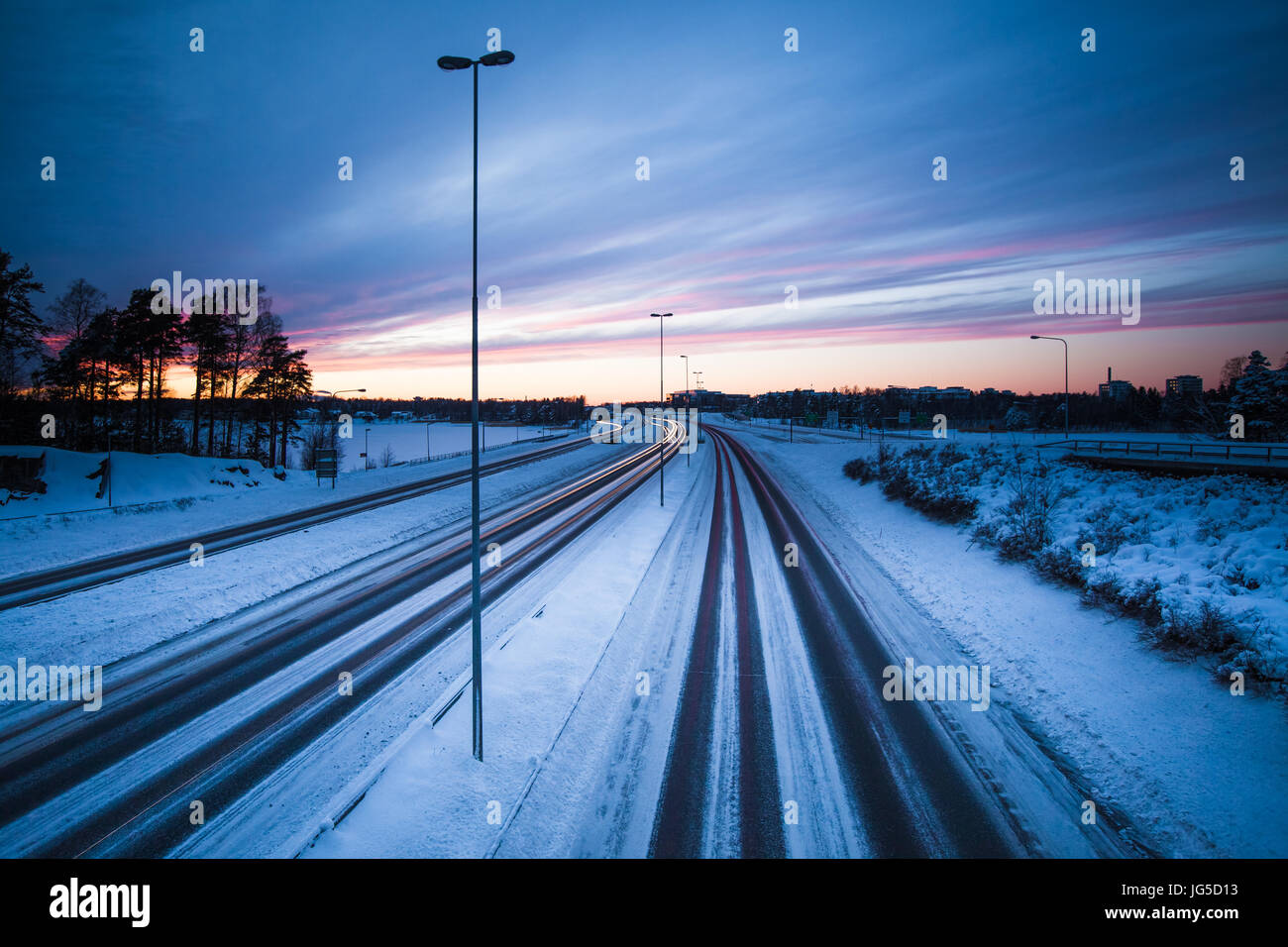 E quasi vuota autostrada in una fredda sera d'inverno in Finlandia Foto Stock