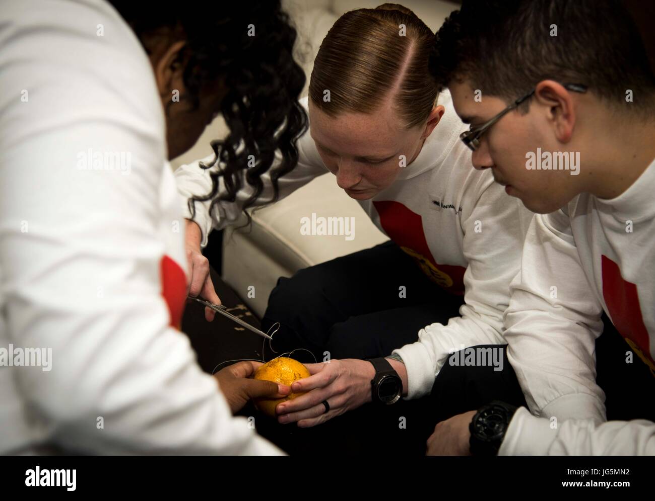 I marinai a bordo della portaerei USS Dwight D. Eisenhower praticano la sutura su arance di addestramento durante la fase di mantenimento del piano ottimizzato di risposta della flotta per mantenere la preparazione medica e le competenze tecniche. Foto Stock