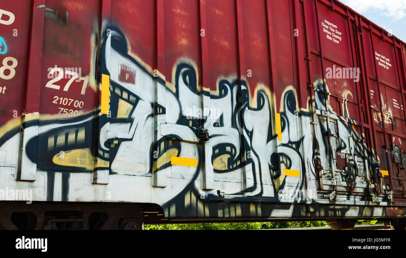 Graffiti bianco sul lato di un trenino rosso auto Foto Stock