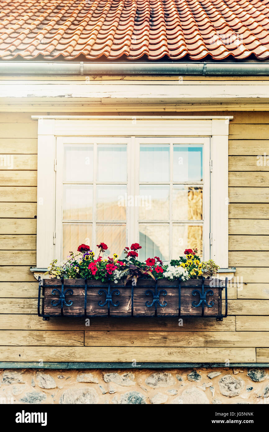 Fioriera appeso davanti della vecchia casa in legno finestra Foto Stock