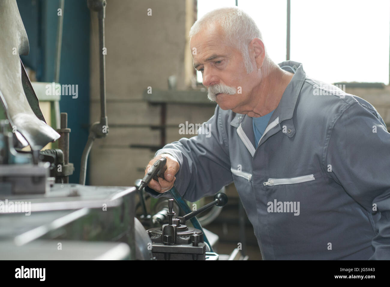 Gioioso uomo maturo nel piazzale di sosta nel lavoro di fabbro Foto Stock