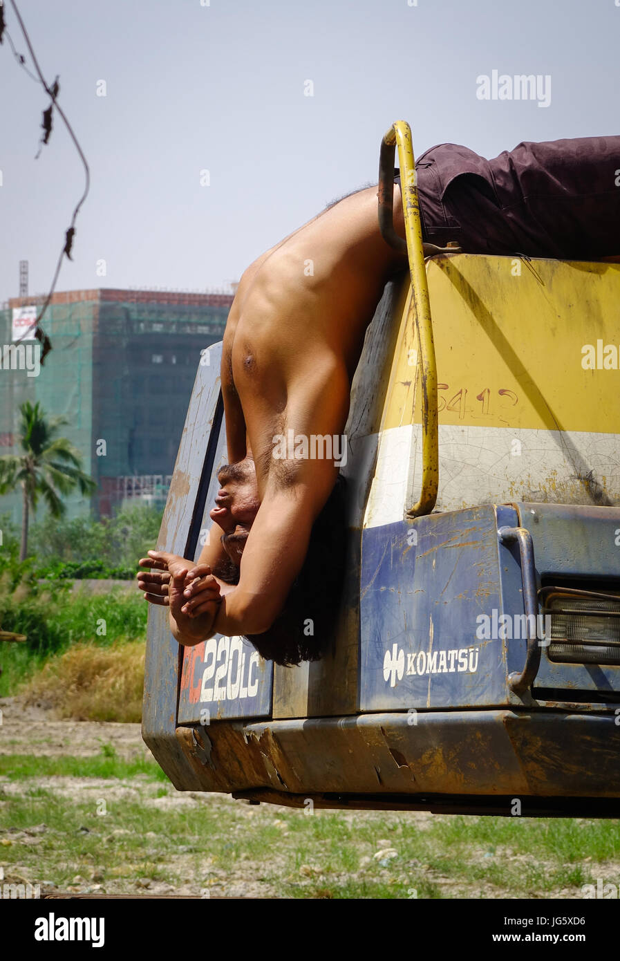Delhi, India - Mar 9, 2017. Un giovane lavoratore facendo esercizi yoga su bulldozer a Delhi, India. Delhi è la quinta città più popolosa del mondo un Foto Stock