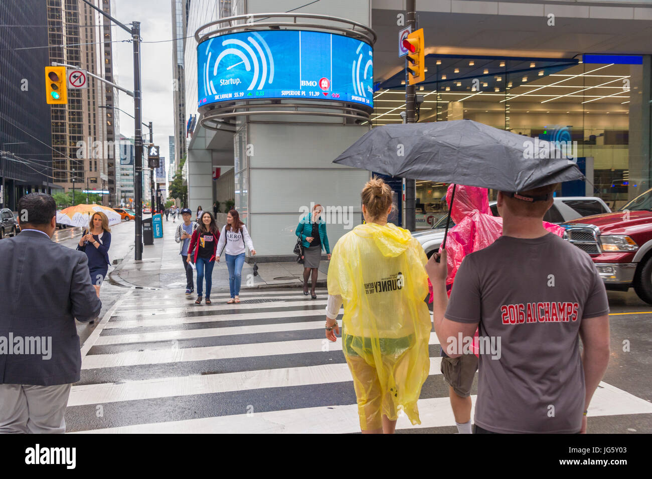 Toronto, Canada - 26 Giugno 2017: folla di persone con ombrelloni e ponchos di pioggia in un giorno di pioggia Foto Stock