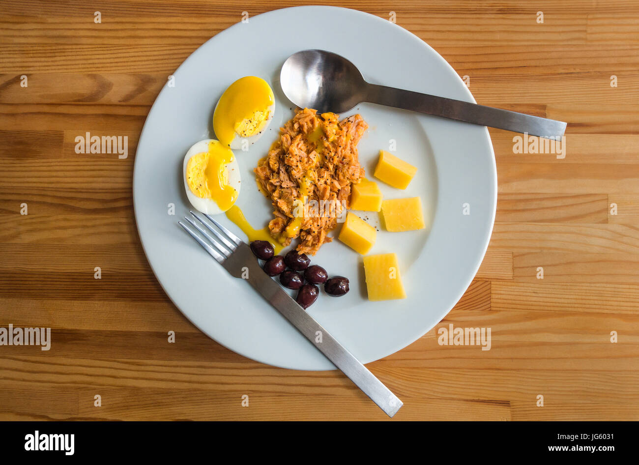 Un piatto di freddo alimentare estiva, uova sode, speziata insalata di tonno, olive greche, il formaggio cheddar Foto Stock