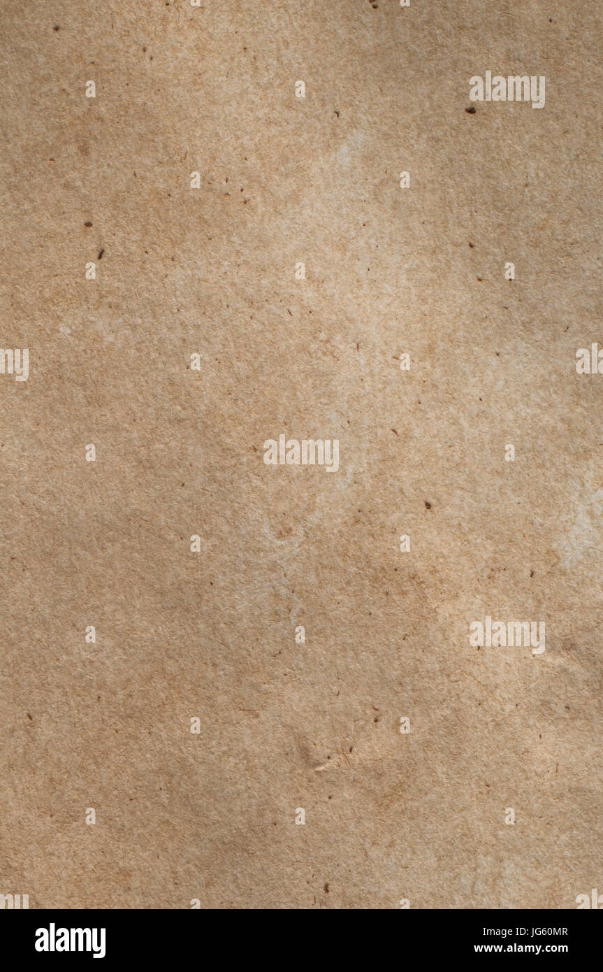 Un pezzo di metà-tonico, fibroso textured carta marrone con graffi, fibre e flecks visibile. Foto Stock